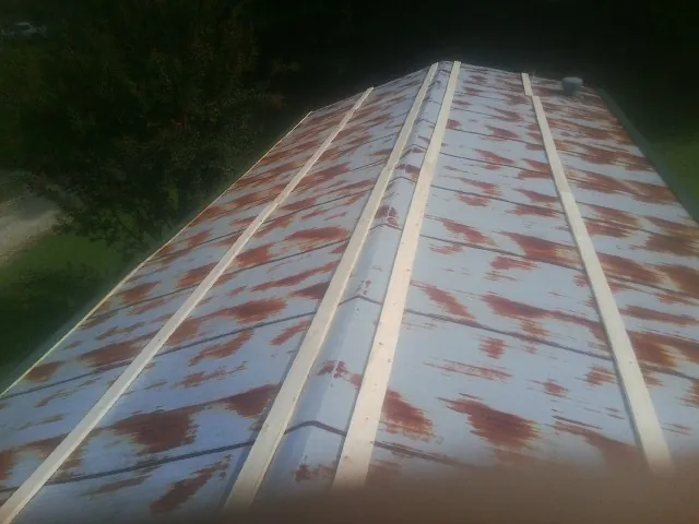 Rusted metal roof panels with new wood purlins before replacement — Storm Damage Roof Repair in Shapleigh by Roofing Brothers