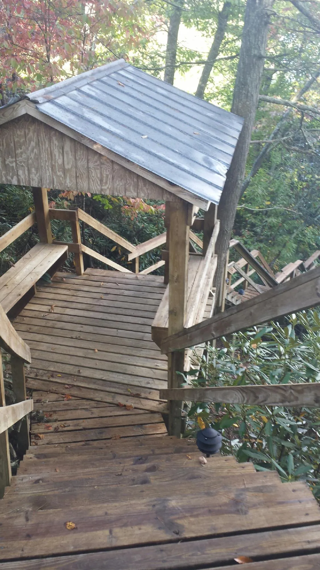 Metal roofed shelter over wooden steps on a wooded walkway — Skylight Repair & Installation work by our crew in Shapleigh