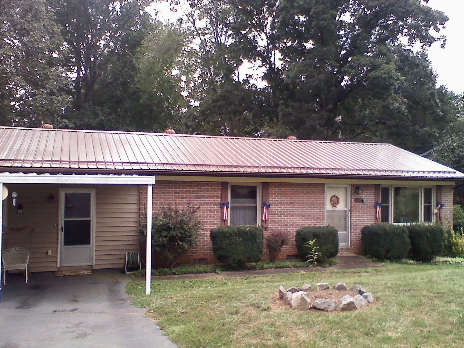 Bronze metal roof and carport on a brick ranch home — Roof Repair work by our crew in Shapleigh